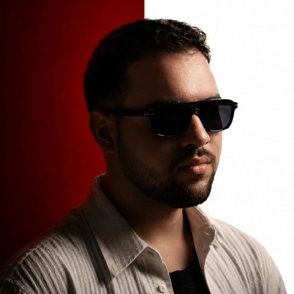 Arminful (Armin Esmaili), Persian DJ and music producer, wearing black sunglasses against a red and white backdrop